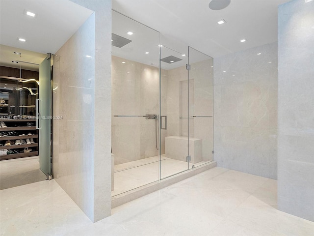 bathroom featuring tile walls and a shower with shower door