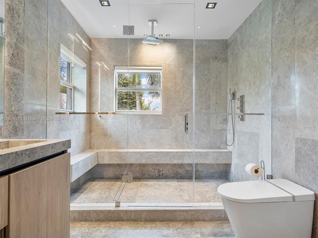 bathroom featuring vanity, a shower with shower door, and tile walls