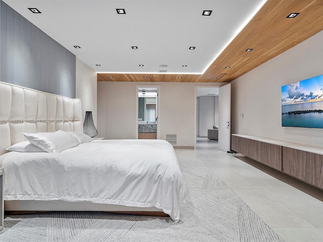 bedroom with connected bathroom and wood ceiling