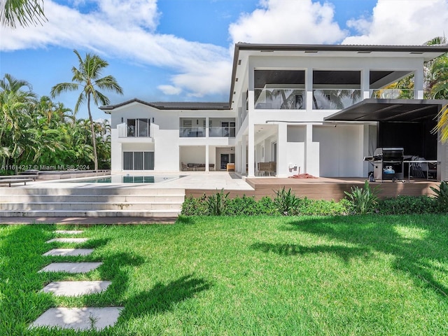 back of property featuring a swimming pool and a lawn