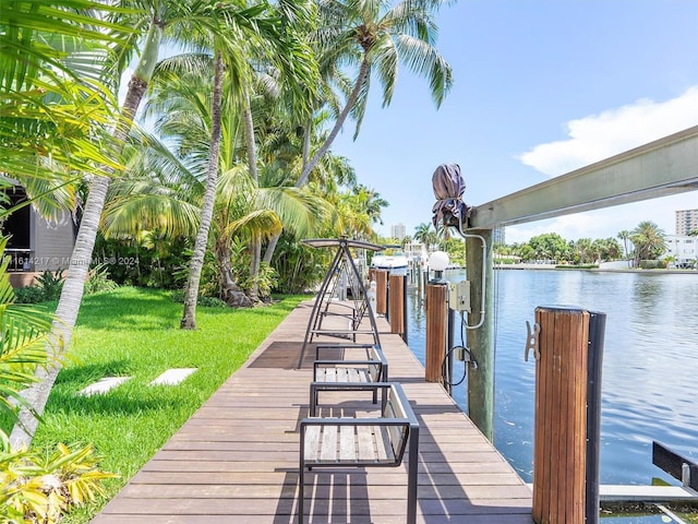 dock area with a lawn and a water view