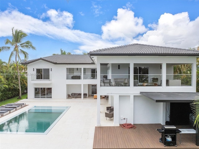 back of property with a balcony and a pool side deck