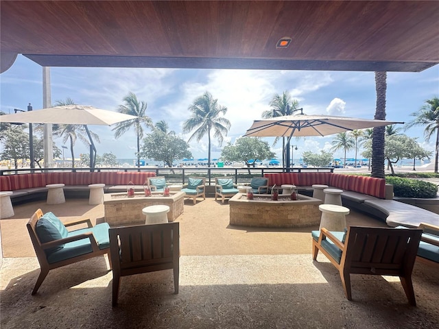 view of patio with an outdoor living space with a fire pit and fence