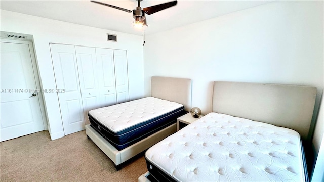 carpeted bedroom with ceiling fan and a closet