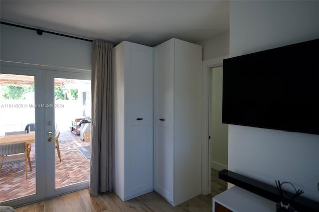 interior space with a closet, light hardwood / wood-style floors, french doors, and access to outside