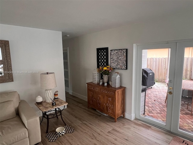 living room featuring french doors, plenty of natural light, and light hardwood / wood-style flooring