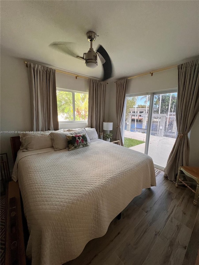 bedroom with dark hardwood / wood-style floors, ceiling fan, and access to exterior