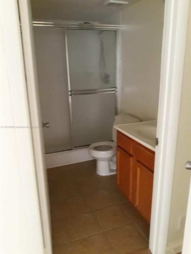 bathroom with vanity, toilet, tile patterned floors, and an enclosed shower