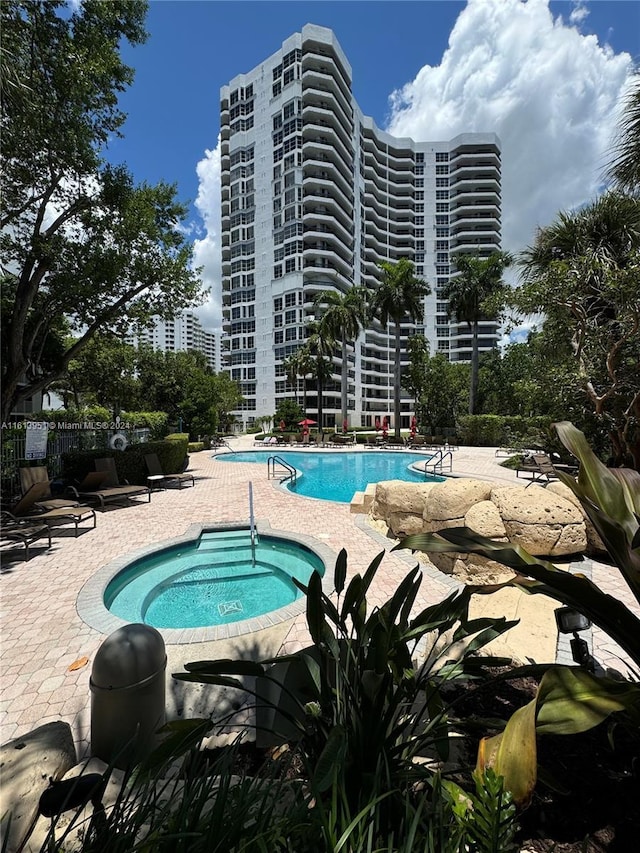 community pool featuring a hot tub and a patio