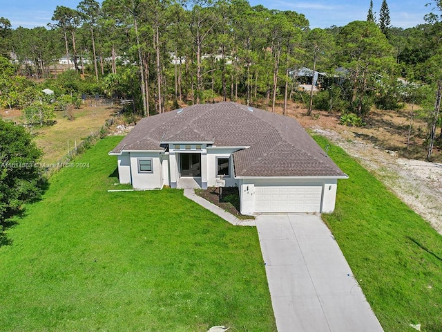 view of front of property with a garage and a front lawn