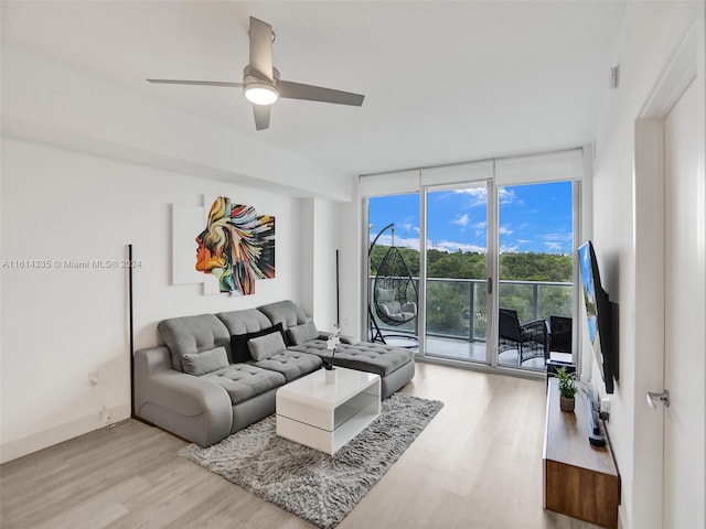 living room featuring expansive windows, light wood-type flooring, and ceiling fan