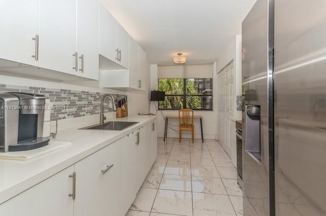 kitchen with white cabinets, backsplash, stainless steel refrigerator with ice dispenser, and sink