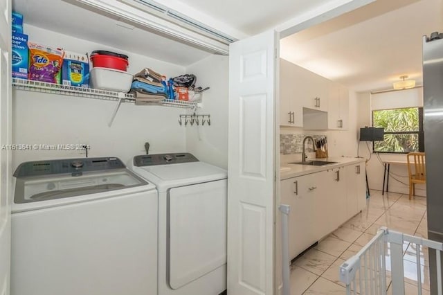 clothes washing area with washer and dryer and sink