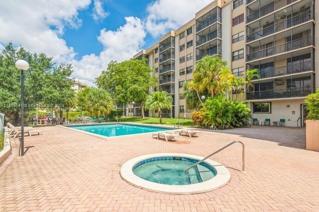 view of swimming pool with a community hot tub and a patio