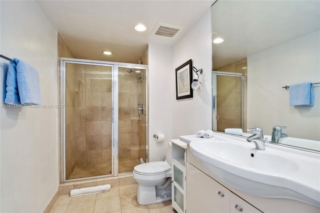 bathroom featuring tile patterned flooring, vanity, an enclosed shower, and toilet