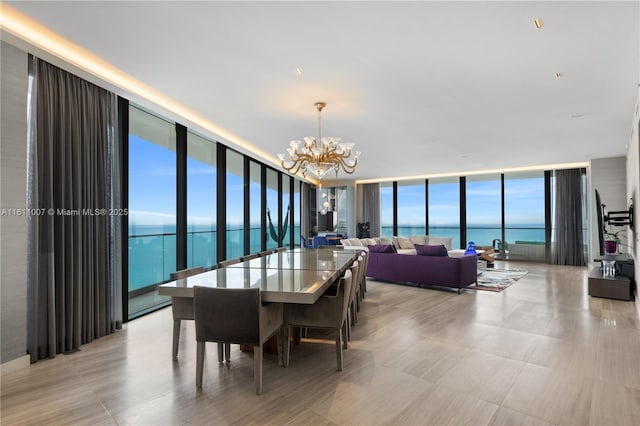 dining area featuring a water view, a wall of windows, and a chandelier