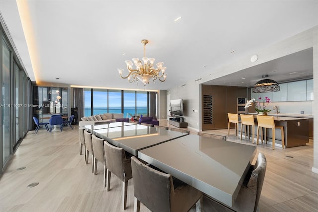 dining space featuring expansive windows, an inviting chandelier, and light hardwood / wood-style floors