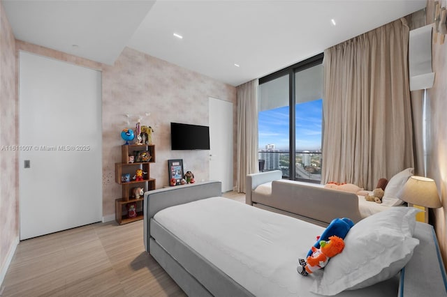 bedroom featuring a wall of windows and access to outside