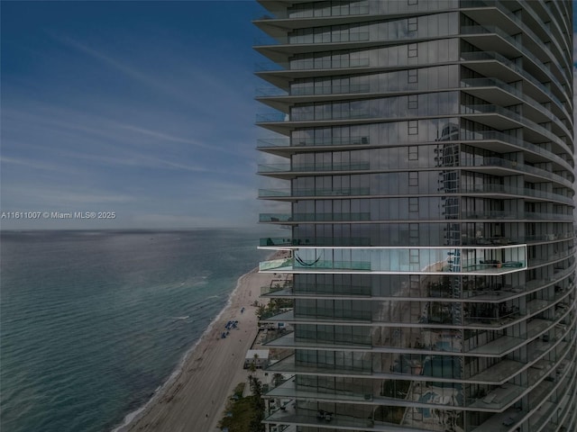 view of building exterior with a view of the beach and a water view