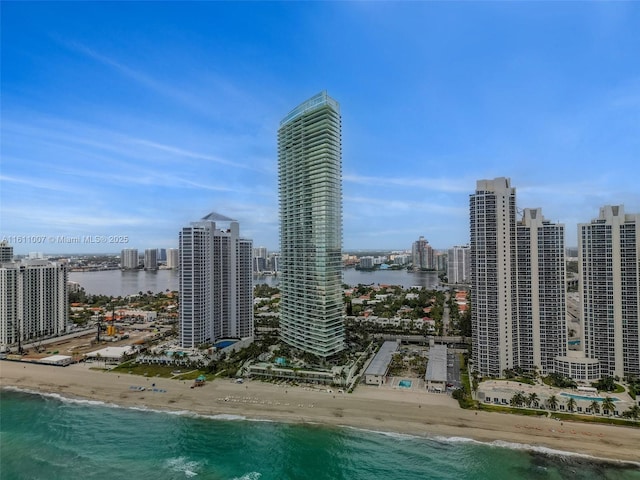 property's view of city featuring a water view and a view of the beach