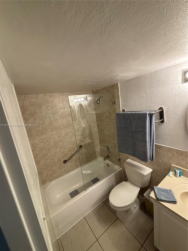 full bathroom featuring toilet, tile walls, a textured ceiling, and tile patterned flooring