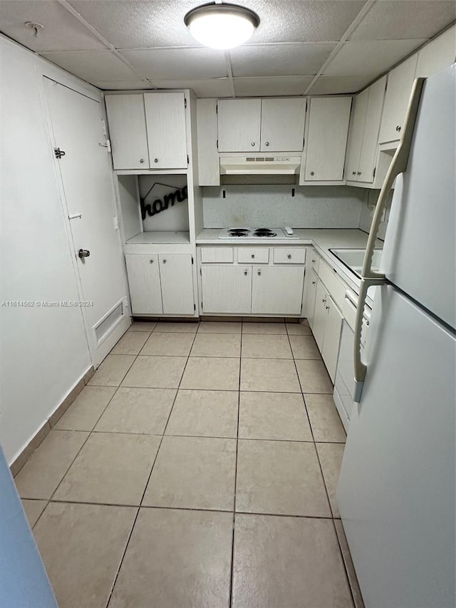 kitchen featuring light tile patterned floors, white appliances, and white cabinetry