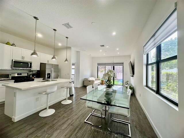 dining room featuring a textured ceiling, dark hardwood / wood-style floors, and sink