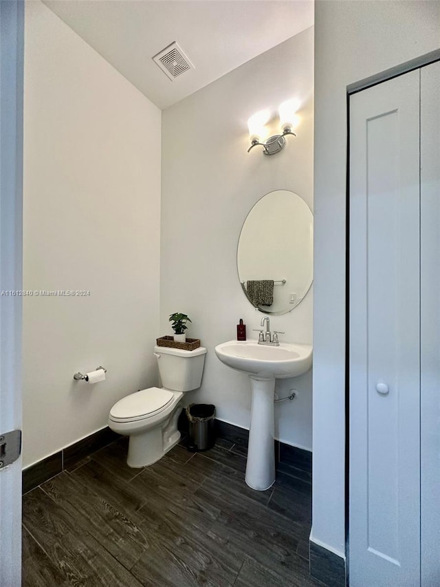 bathroom with toilet and hardwood / wood-style flooring