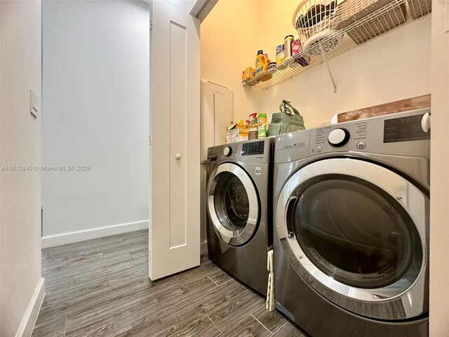 laundry area with dark wood-type flooring and washer and clothes dryer