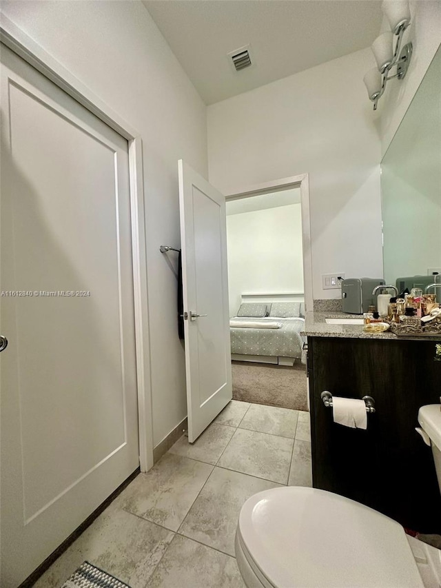 bathroom with tile patterned flooring, toilet, and vanity