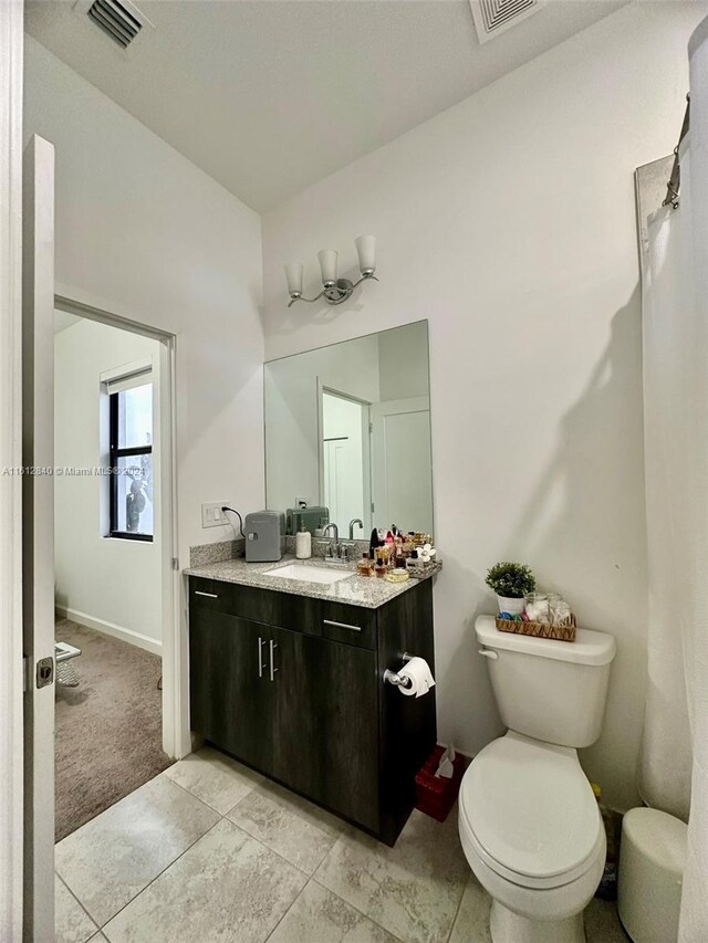 bathroom with tile patterned flooring, toilet, and vanity