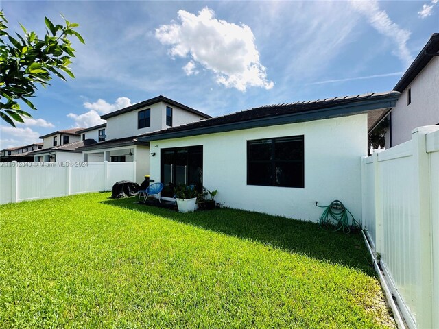 rear view of property with a lawn