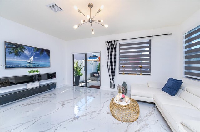 tiled living room with a notable chandelier and a healthy amount of sunlight