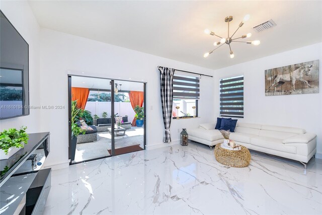 tiled living room with a notable chandelier