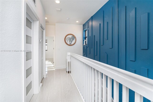 hall featuring light tile patterned flooring