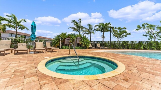 view of pool with an in ground hot tub and a patio