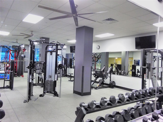 gym with ceiling fan and a paneled ceiling