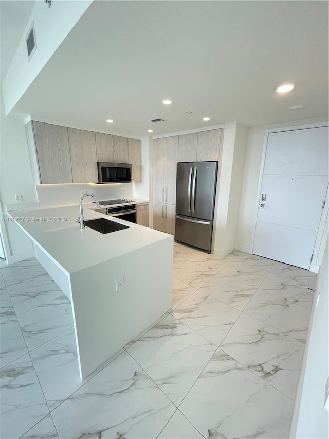 kitchen featuring light brown cabinetry, kitchen peninsula, stainless steel appliances, sink, and light tile floors