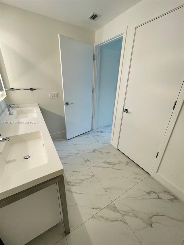 bathroom featuring dual bowl vanity and tile flooring