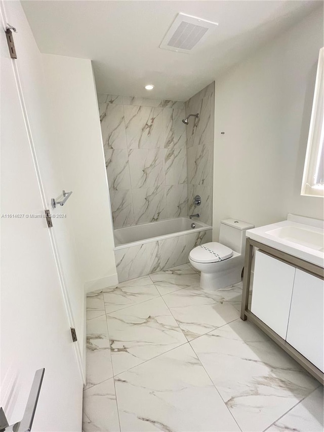 full bathroom with tile floors, toilet, vanity, and tiled shower / bath