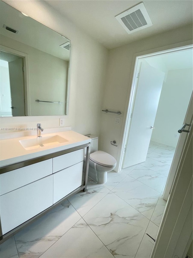 bathroom featuring tile floors, vanity, and toilet