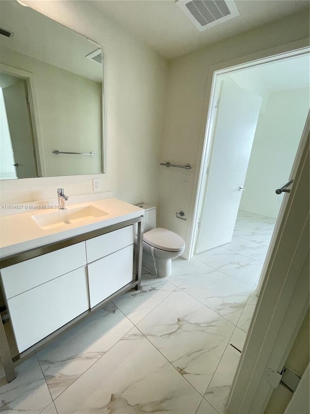 bathroom featuring vanity, toilet, and tile floors