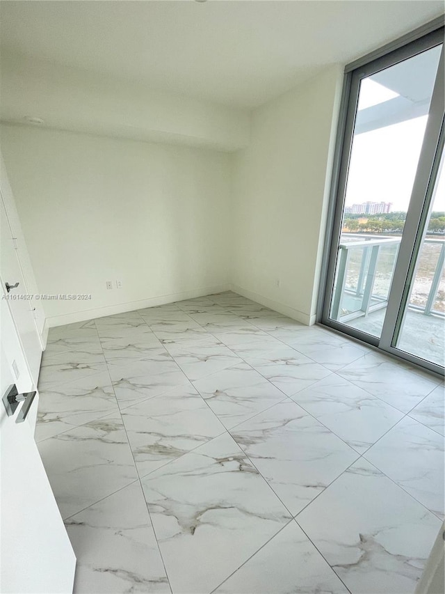 tiled spare room with a wealth of natural light and a wall of windows