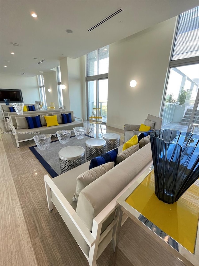 living room featuring a healthy amount of sunlight, a wall of windows, and hardwood / wood-style flooring