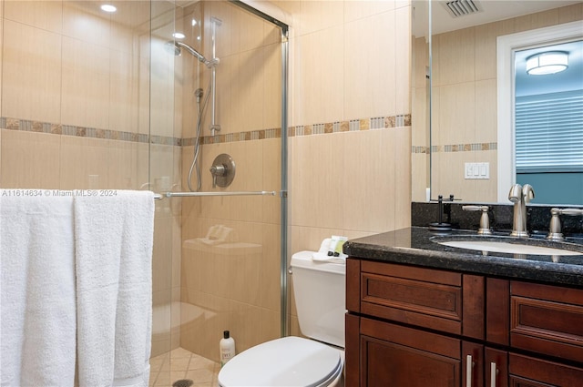 bathroom featuring tile walls, an enclosed shower, and toilet