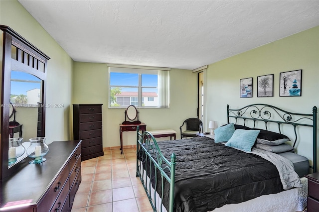 tiled bedroom featuring a textured ceiling