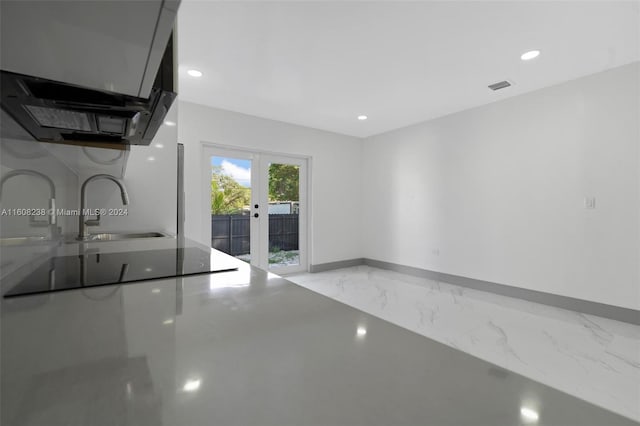 kitchen featuring french doors, wall chimney exhaust hood, and sink