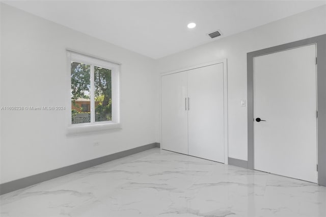 unfurnished bedroom featuring a closet and light tile patterned floors