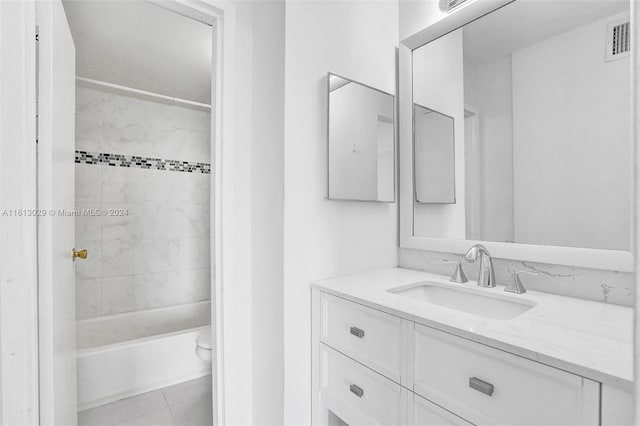 full bathroom with tiled shower / bath, vanity, toilet, and tile patterned flooring