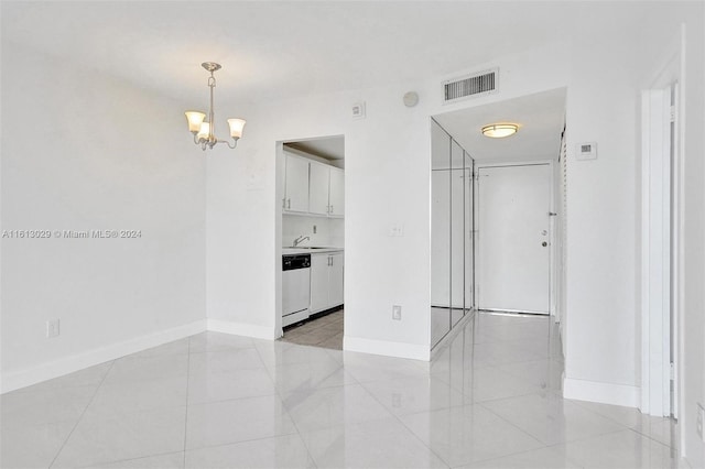 tiled empty room with sink and a notable chandelier